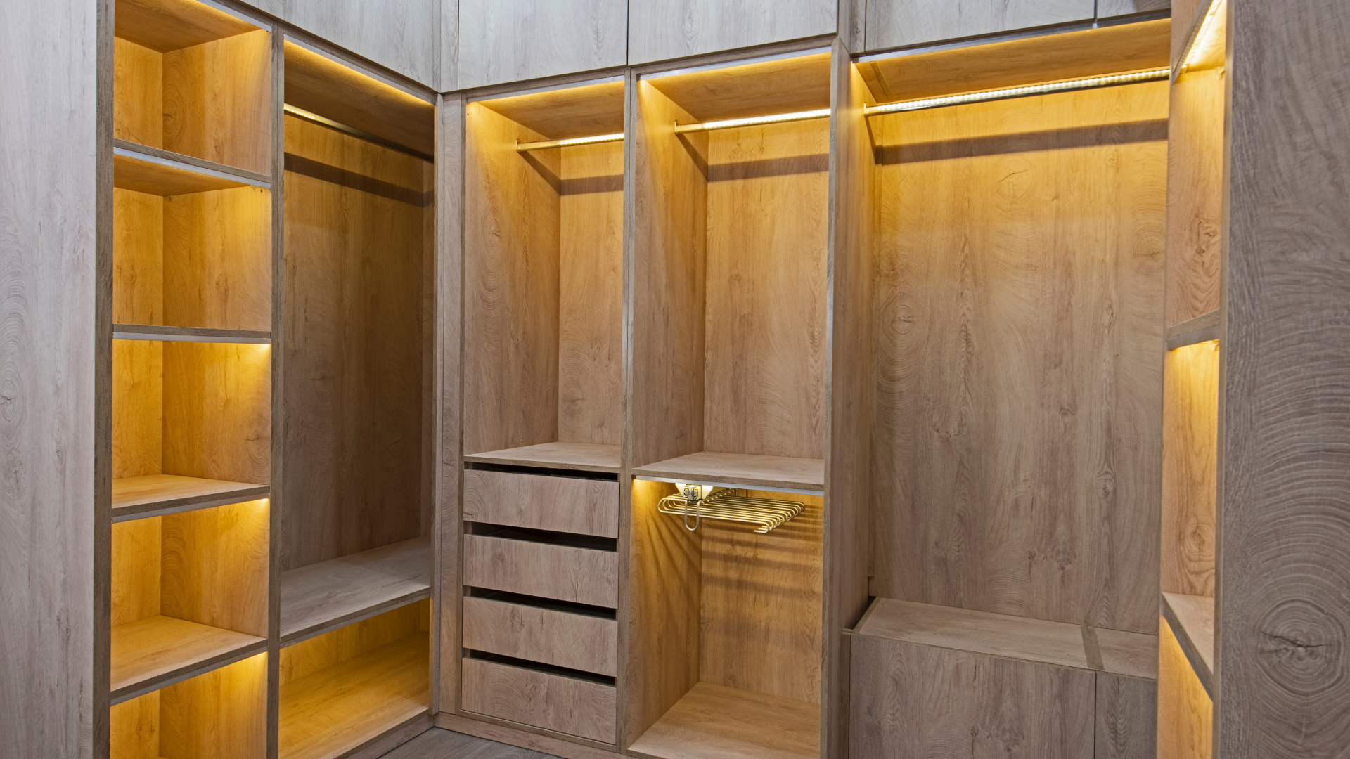 Warm wooden closet with built-in lighting and multiple storage compartments.