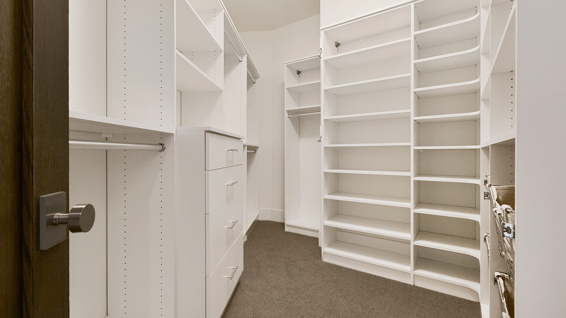 White walk-in closet with shelves, drawers, and hanging rods for a clean, modern storage solution.